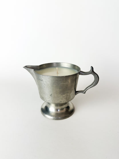 Metal pitcher candle on a white background