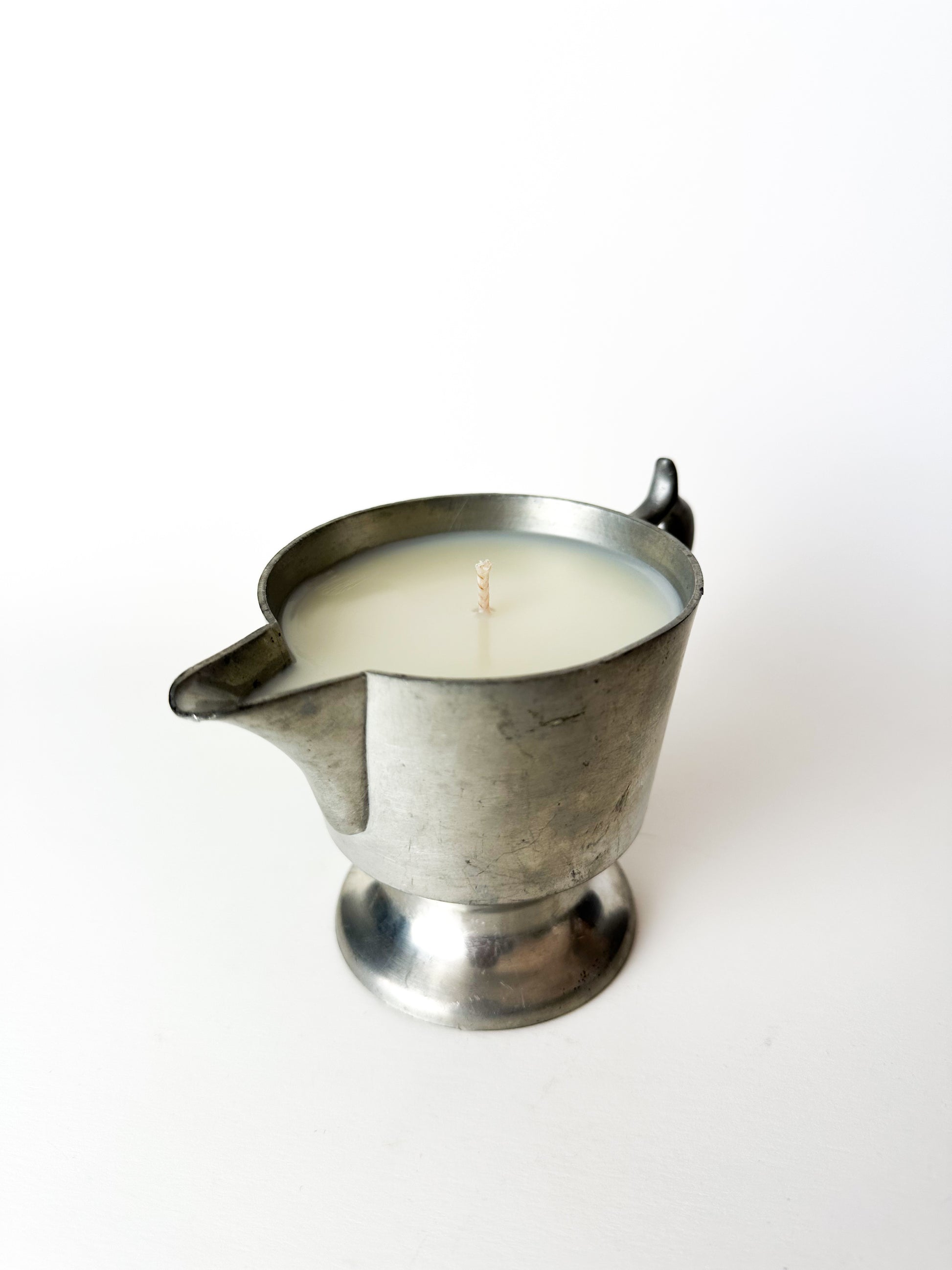 Candle in a metal container on a white background