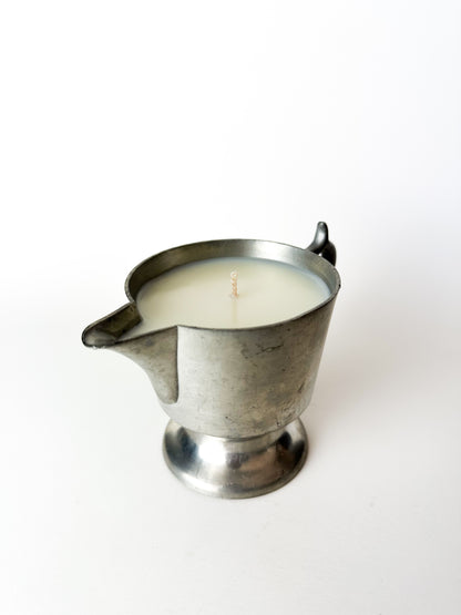 Candle in a metal container on a white background