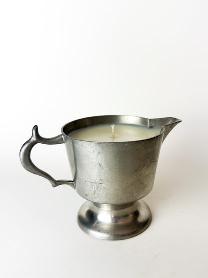 Metal pitcher candle on a white background