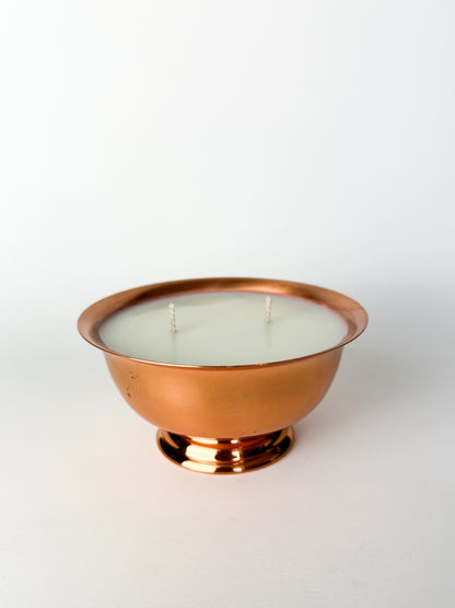 Candle in a copper holder on a white background