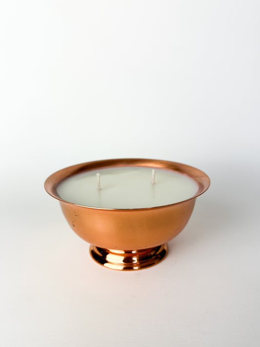 Candle in a copper holder on a white background