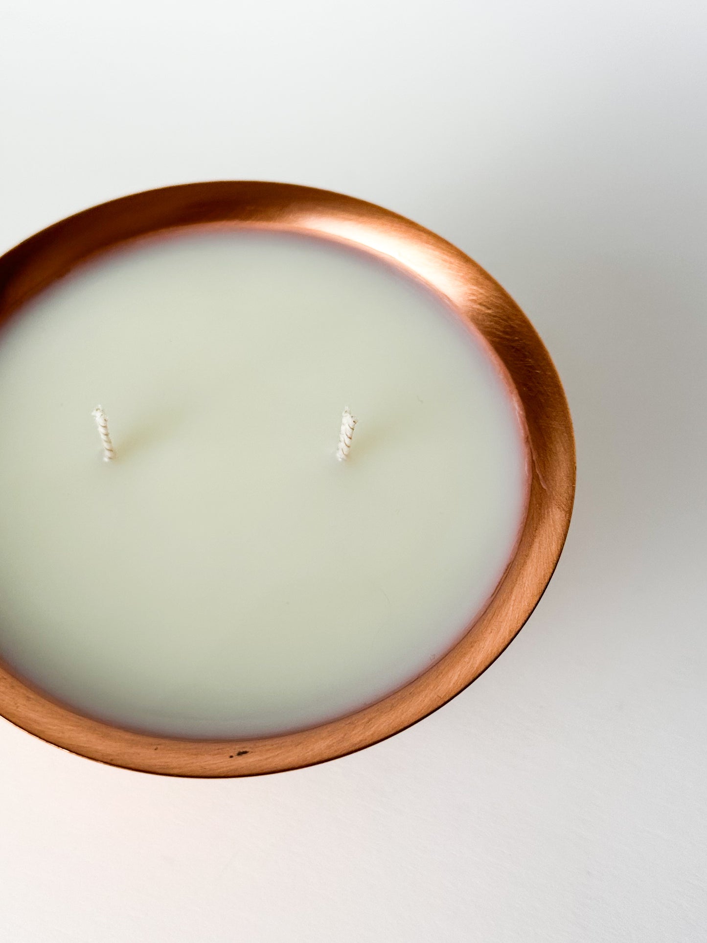 Candle in a copper holder on a white background