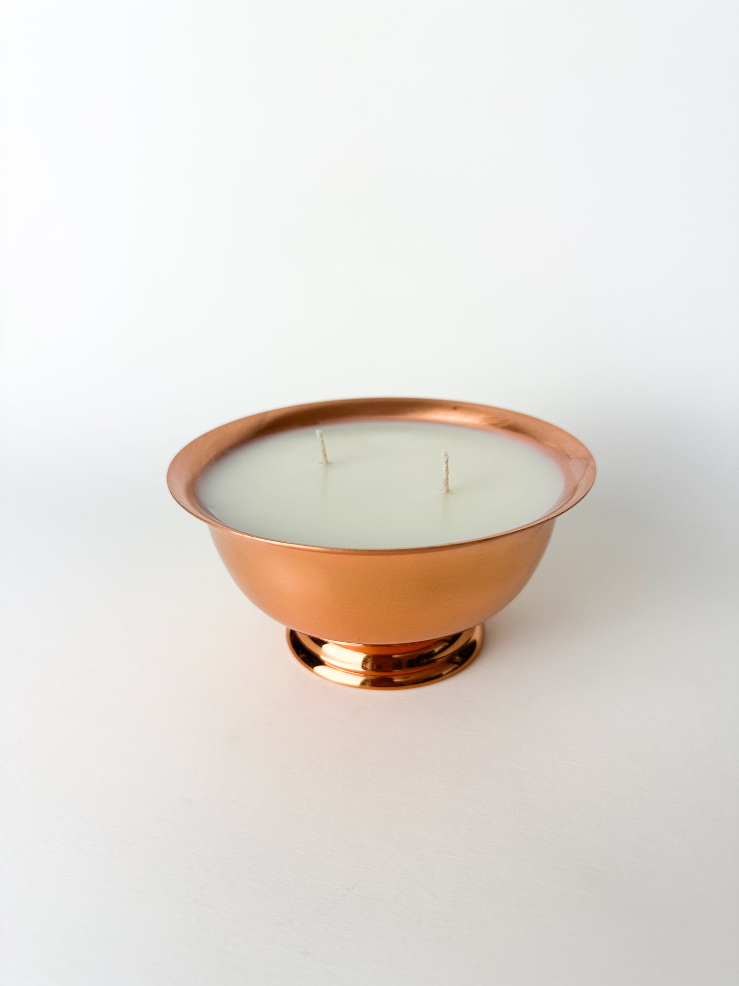 Candle in a copper holder on a white background