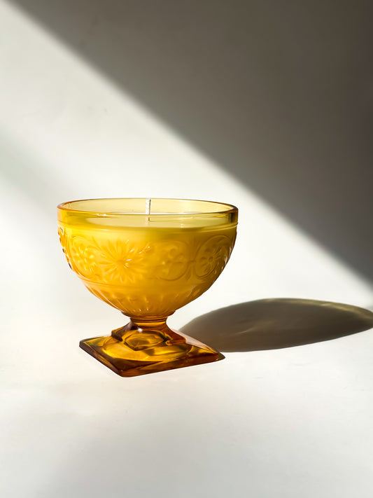 Amber glass bowl with embossed design on a white surface with a soft shadow