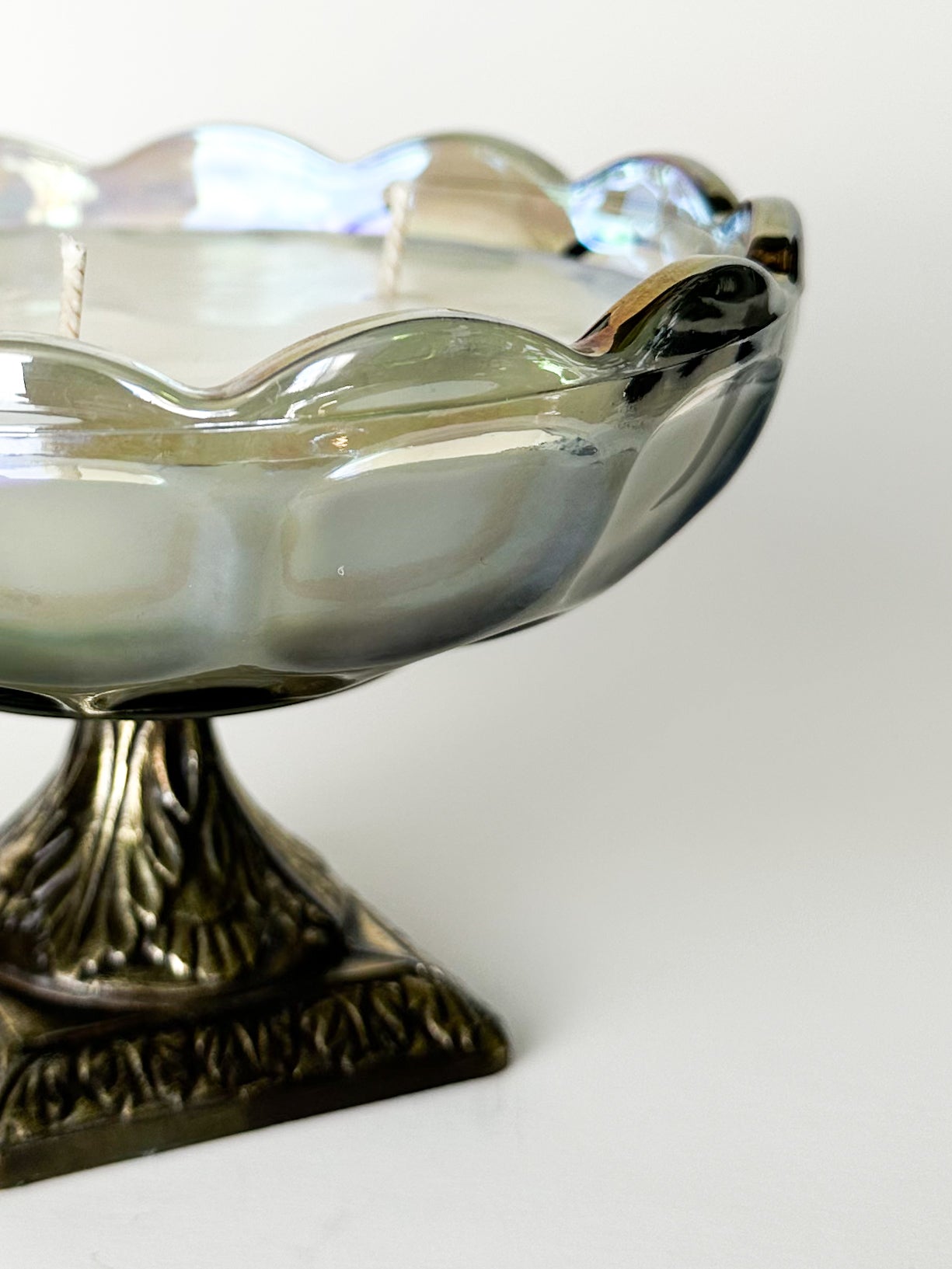 Decorative glass bowl with a metallic base on a white background
