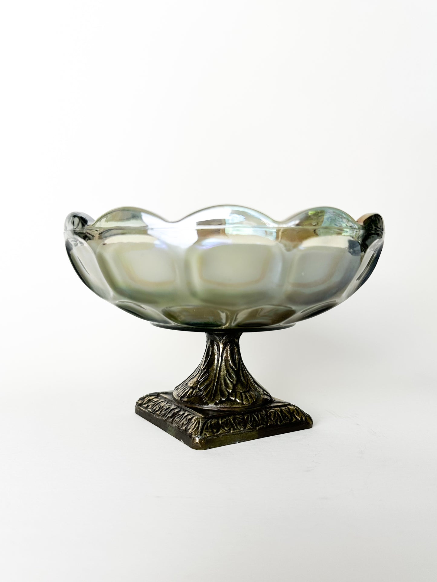 Decorative glass bowl with metal base on a white background