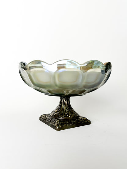 Decorative glass bowl with metal base on a white background