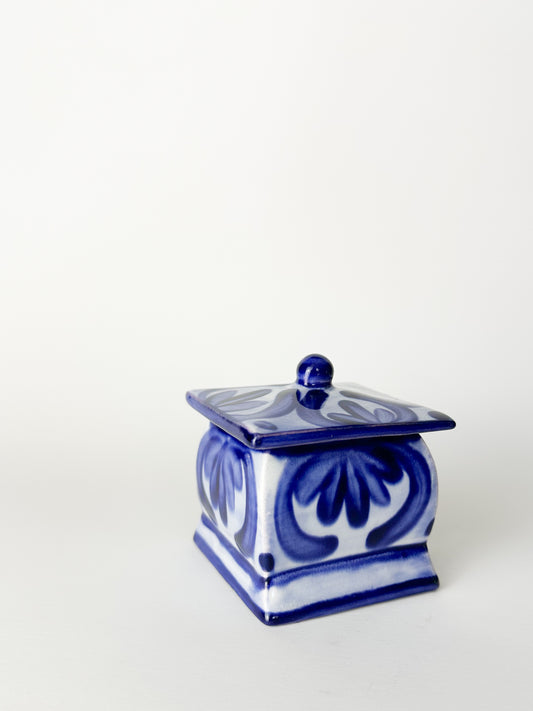 Blue and white ceramic container with lid on a white background