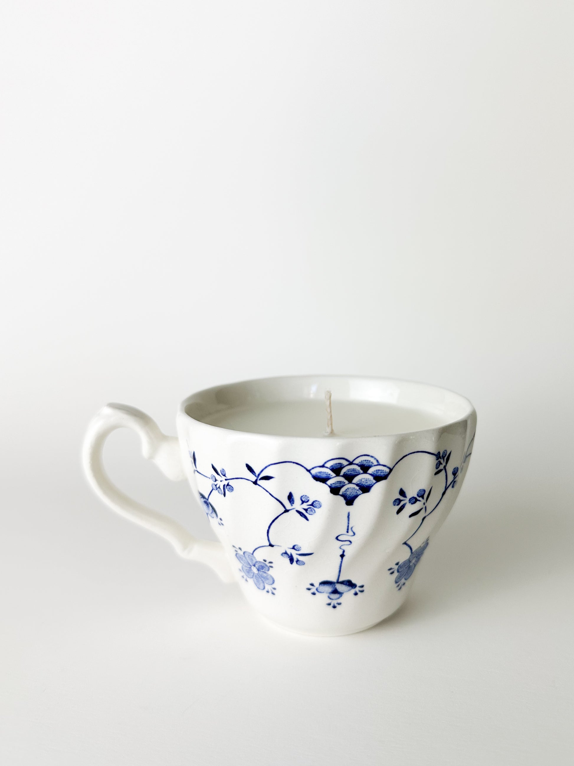 White ceramic mug with blue floral patterns on a white background