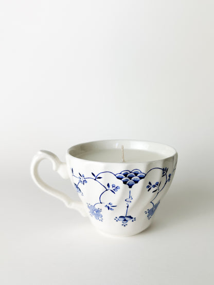 White ceramic mug with blue floral patterns on a white background