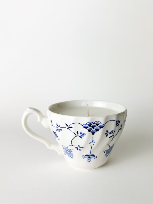 White ceramic mug with blue floral patterns on a white background