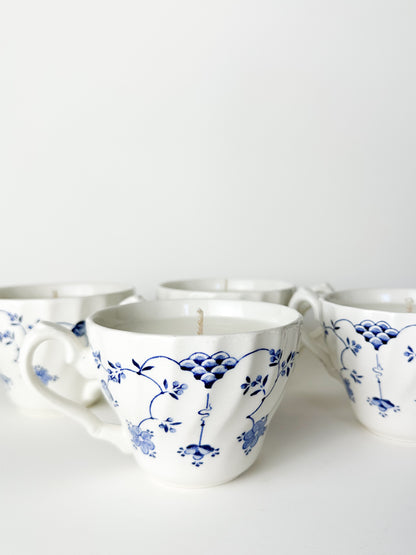 White ceramic cups with blue floral patterns on a white background