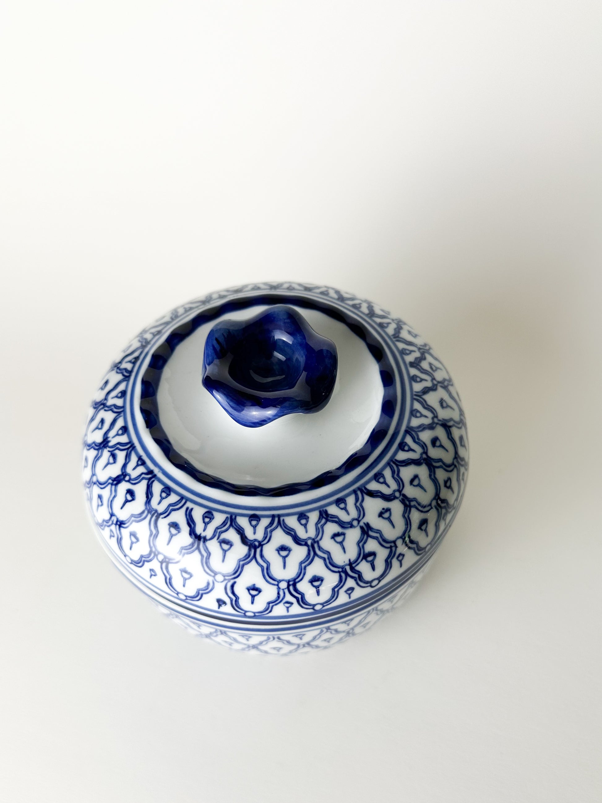 Blue and white ceramic jar with lid on a white background