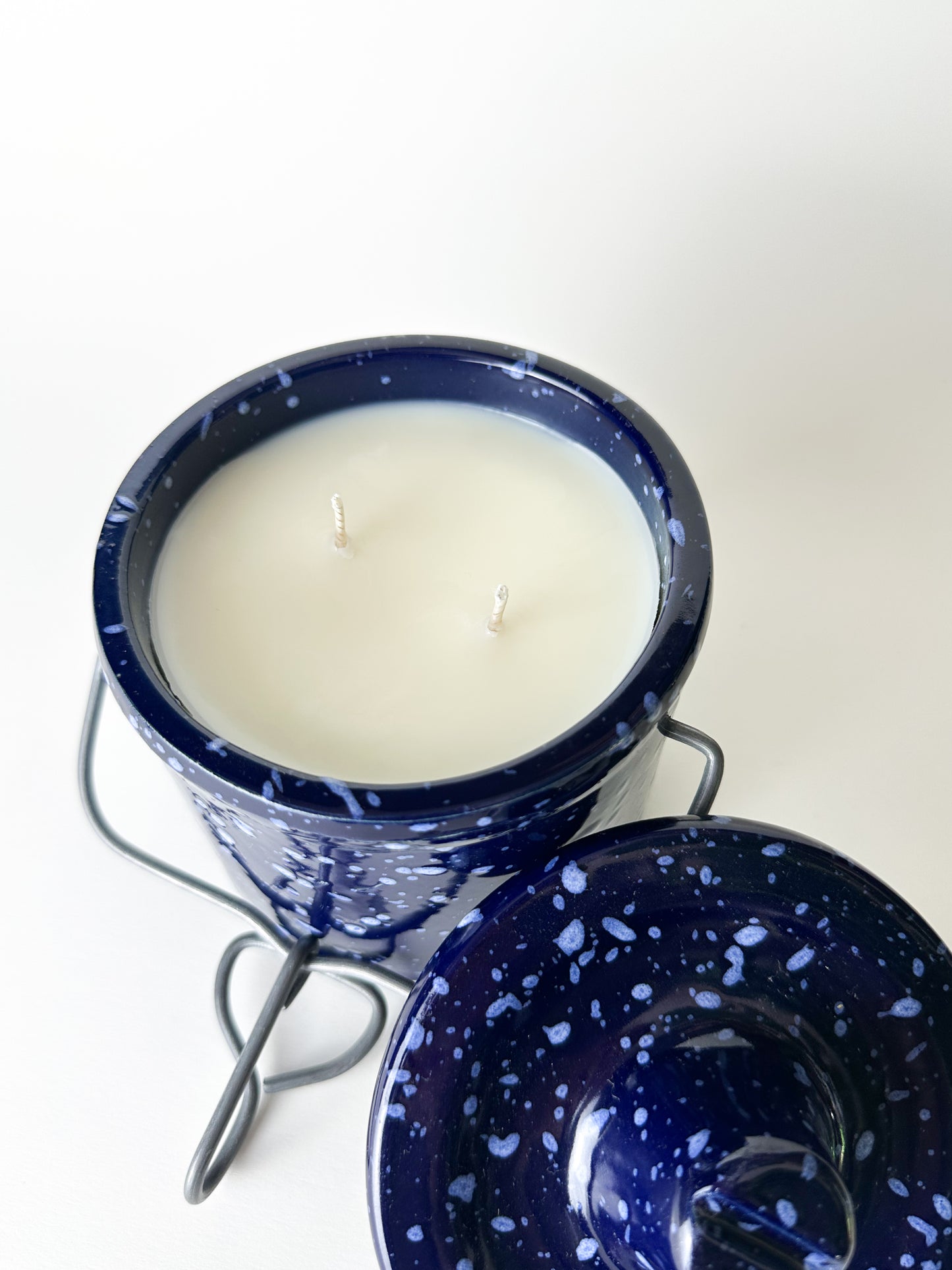 Candle in a blue speckled container on a white background
